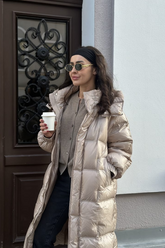 a lady in a grey cardigan, a pair of black pants and a long rose gold down coat